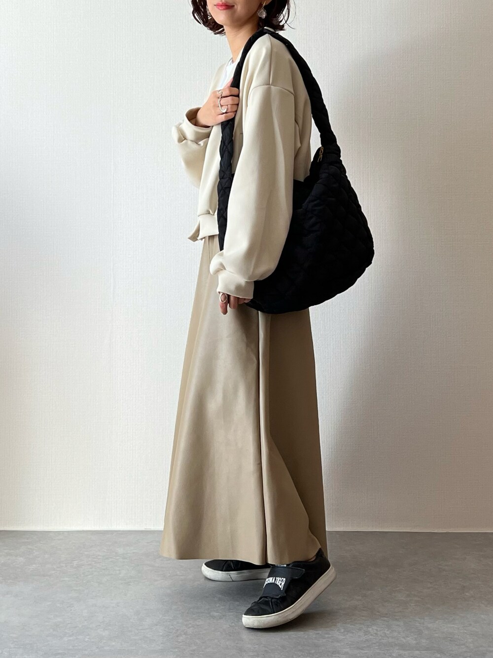 ベージュ系のカーディガン/ボレロ、ホワイト系のTシャツ/カットソー、ブラック系のショルダーバッグを着用したレディースの秋コーディネートの2枚目の写真