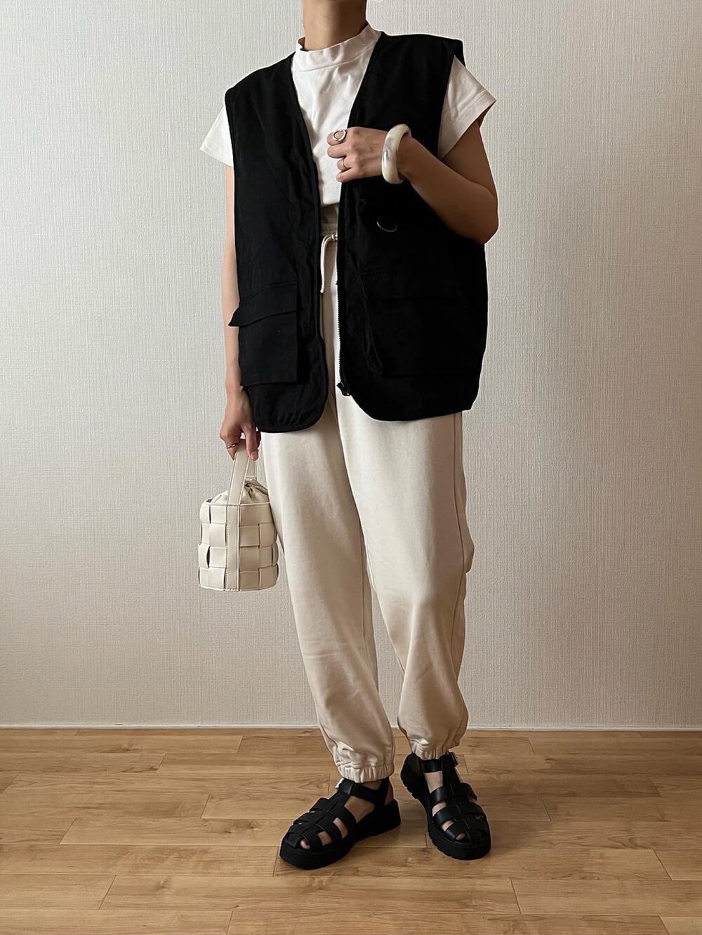 ホワイト系のスウェットパンツ、ホワイト系のTシャツ/カットソー、ブラック系のベストを着用したレディースの夏コーディネートの2枚目の写真