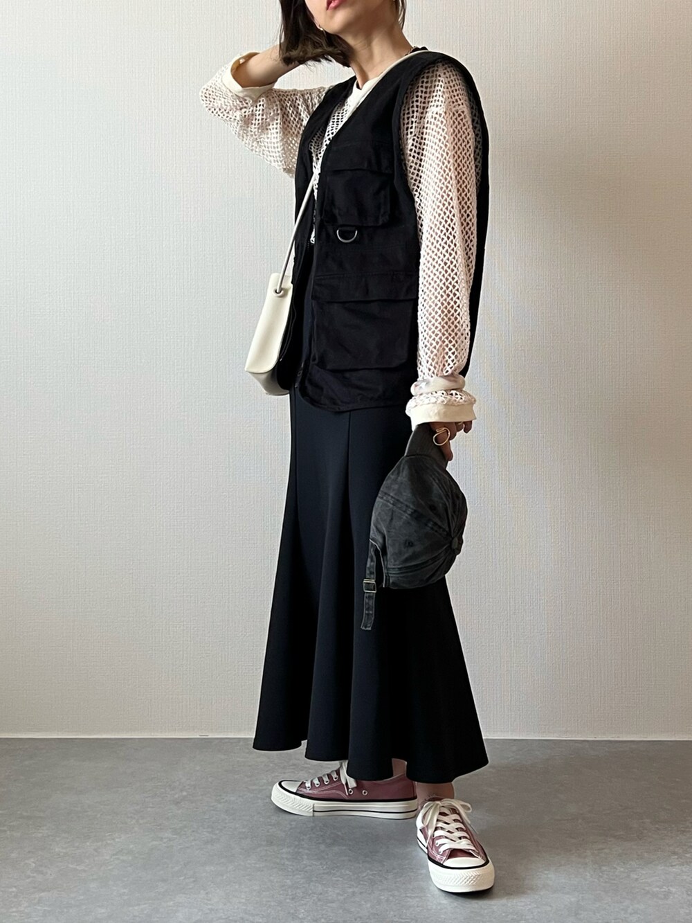 ホワイト系のニット/セーター、ブラック系のベスト、ブラック系のスカートを着用したレディースの夏コーディネートの2枚目の写真