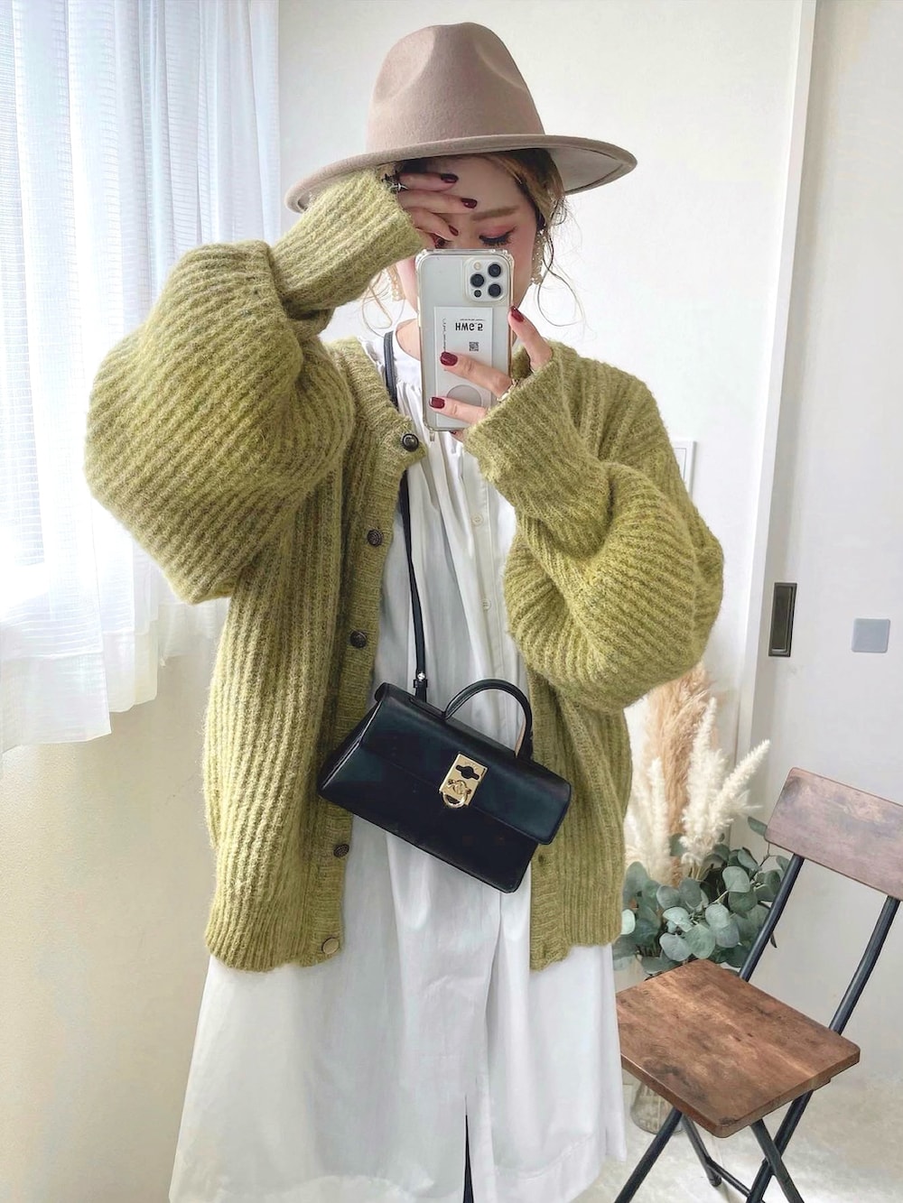 ブラック系のショルダーバッグ、グリーン系のカーディガン/ボレロ、ベージュ系のハットを着用したレディースの秋コーディネートの3枚目の写真