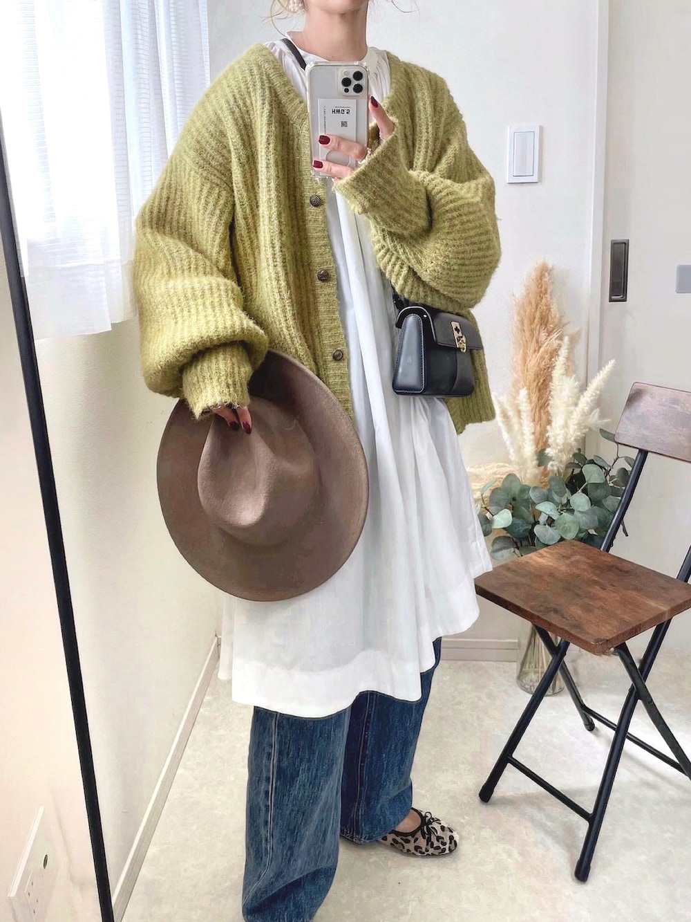 ブラック系のショルダーバッグ、グリーン系のカーディガン/ボレロ、ベージュ系のハットを着用したレディースの秋コーディネートの2枚目の写真