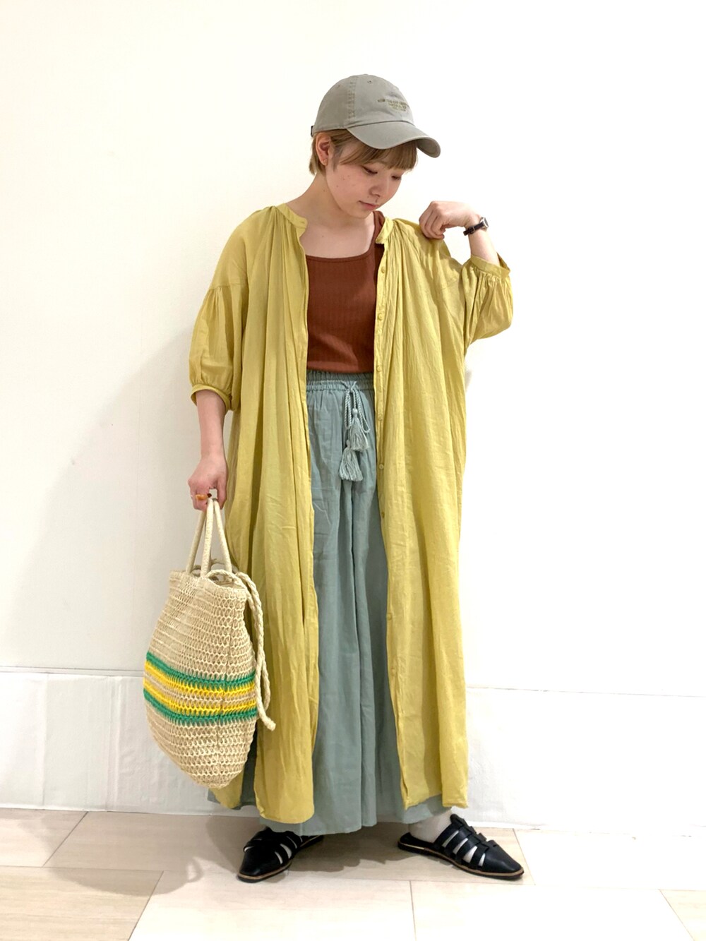 イエロー系のワンピース、ブラウン系のタンクトップ、グリーン系のその他パンツを着用したレディースの夏コーディネートの2枚目の写真