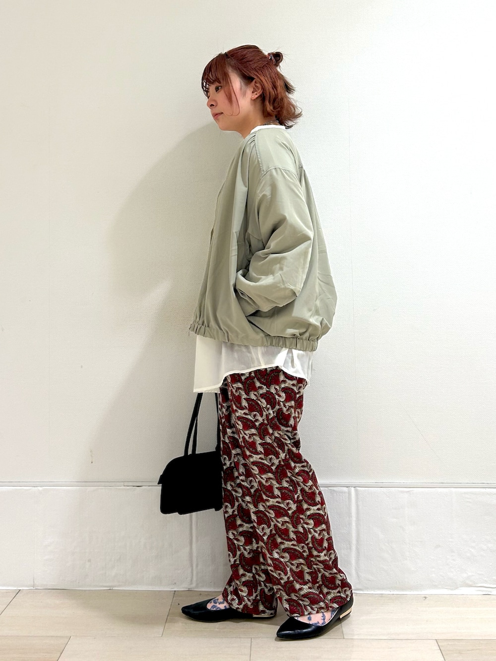 グリーン系のその他アウター、ホワイト系のチュニック、レッド系のその他パンツを着用したレディースの春コーディネートの2枚目の写真