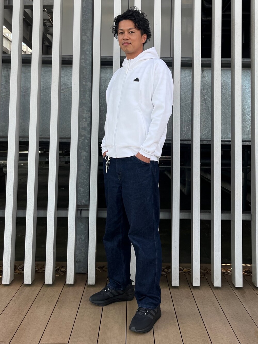 ホワイト系のトップス、ブラック系のスニーカーを着用したメンズの秋コーディネートの2枚目の写真