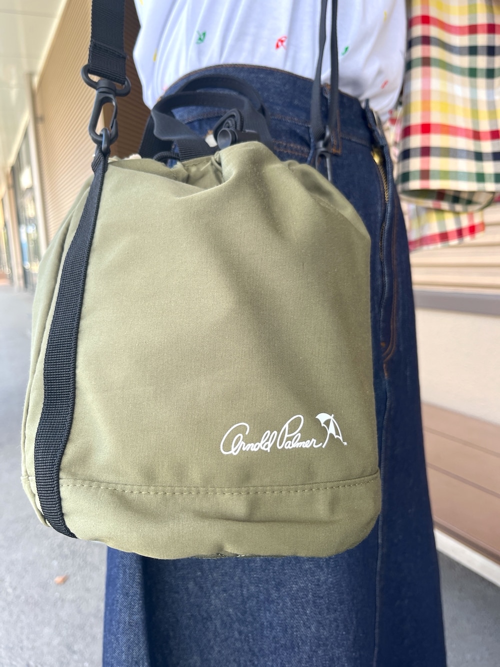 ブルー系のデニムスカート、ホワイト系のTシャツ/カットソー、グリーン系のショルダーバッグを着用したレディースの夏コーディネートの5枚目の写真