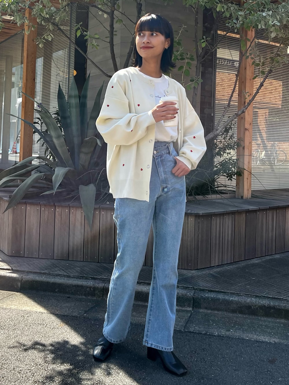 ホワイト系のカーディガン/ボレロ、ブルー系のデニムパンツ、ホワイト系のTシャツ/カットソーを着用したレディースの秋コーディネートの3枚目の写真