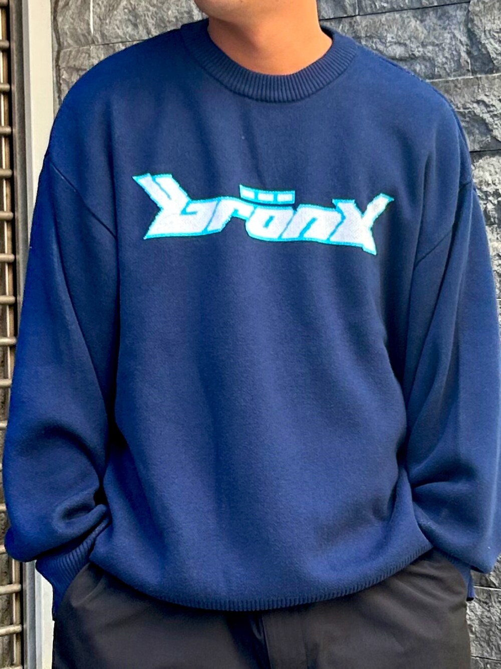 ブルー系のニット/セーター、ブラック系のカーゴパンツを着用したメンズの夏コーディネートの2枚目の写真