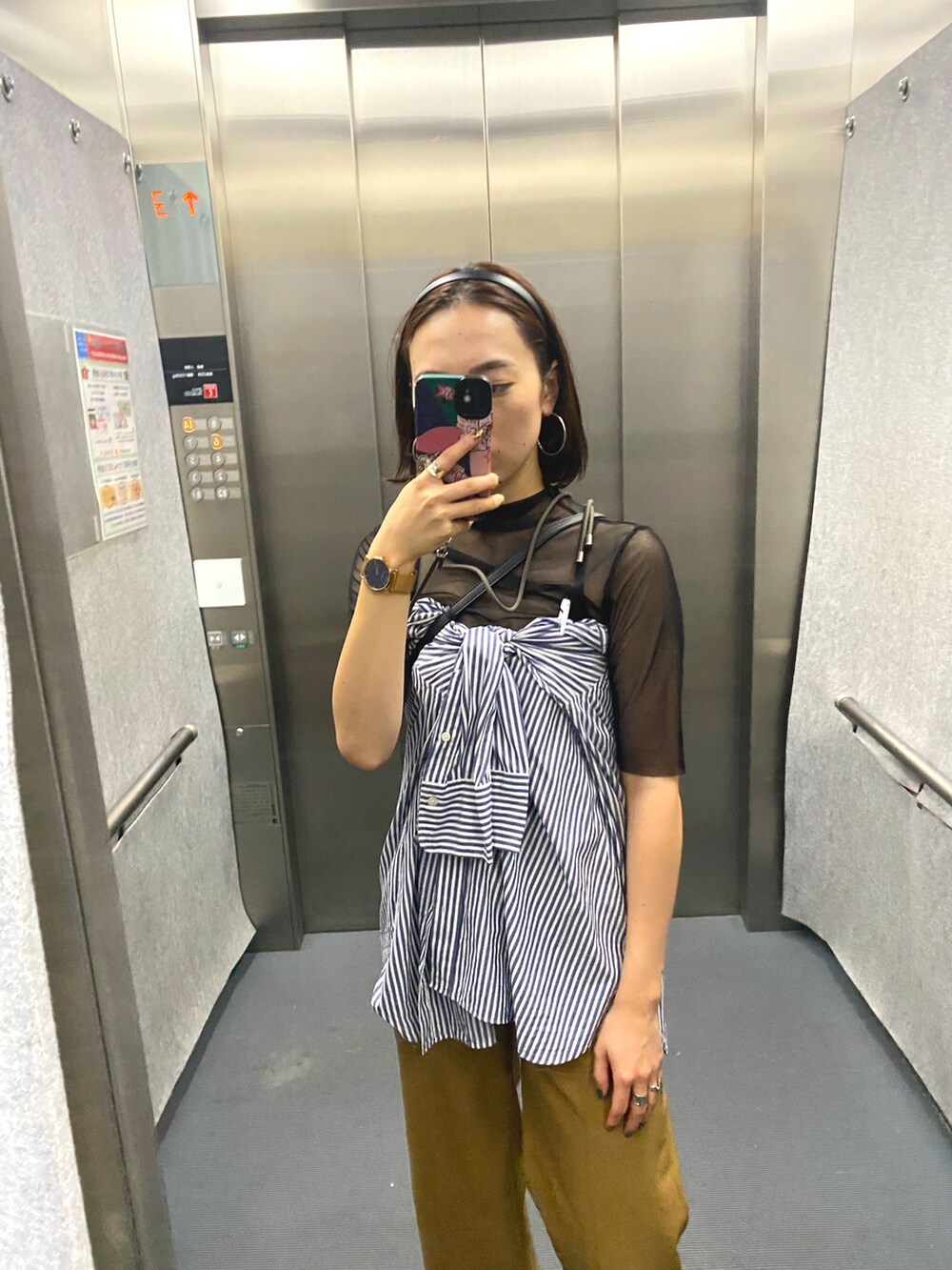 ブルー系のシャツ/ブラウス、オレンジ系のパンツ、ベージュ系のスニーカーを着用したレディースの夏コーディネートの3枚目の写真