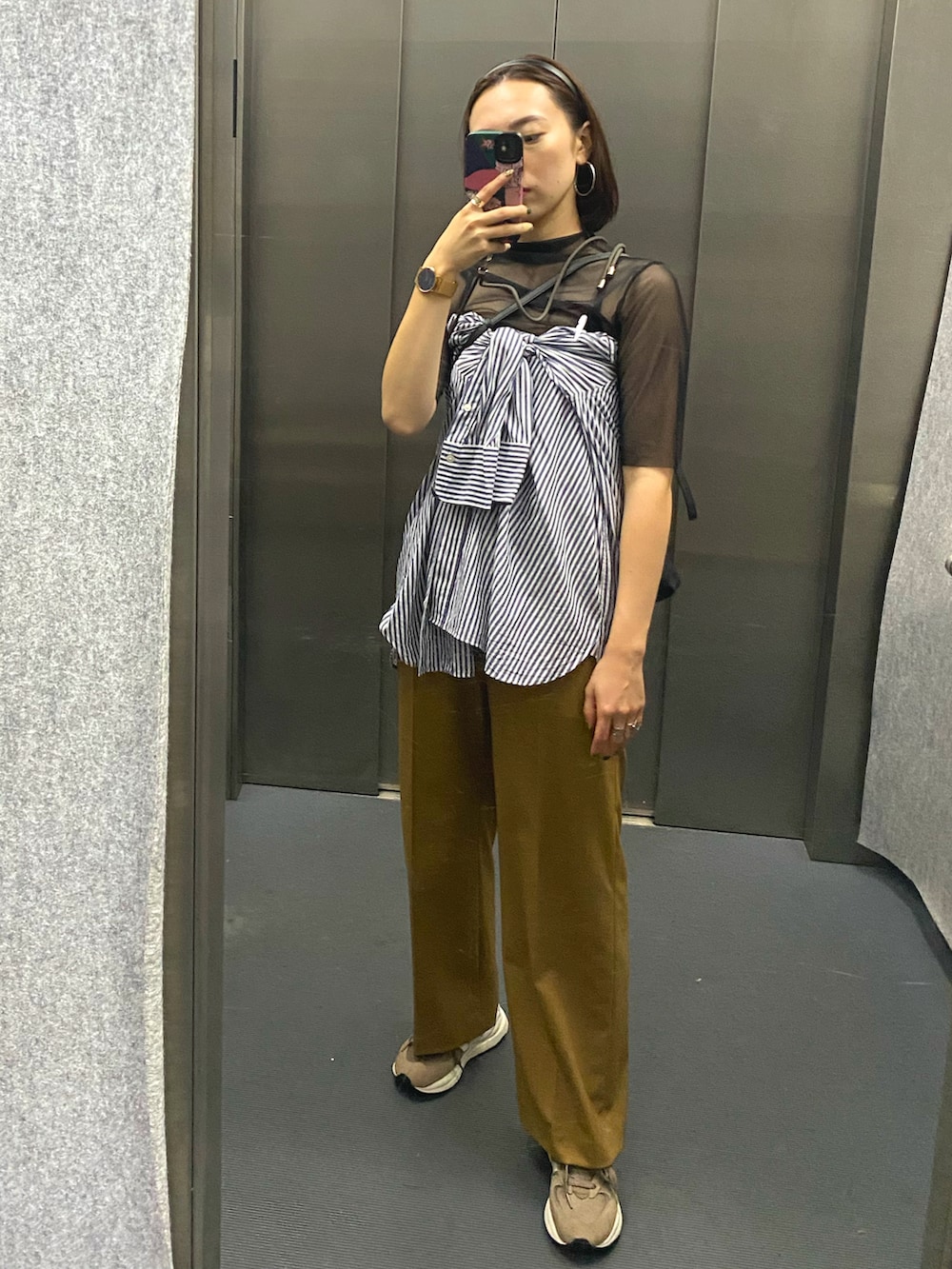 ブルー系のシャツ/ブラウス、オレンジ系のパンツ、ベージュ系のスニーカーを着用したレディースの夏コーディネートの2枚目の写真