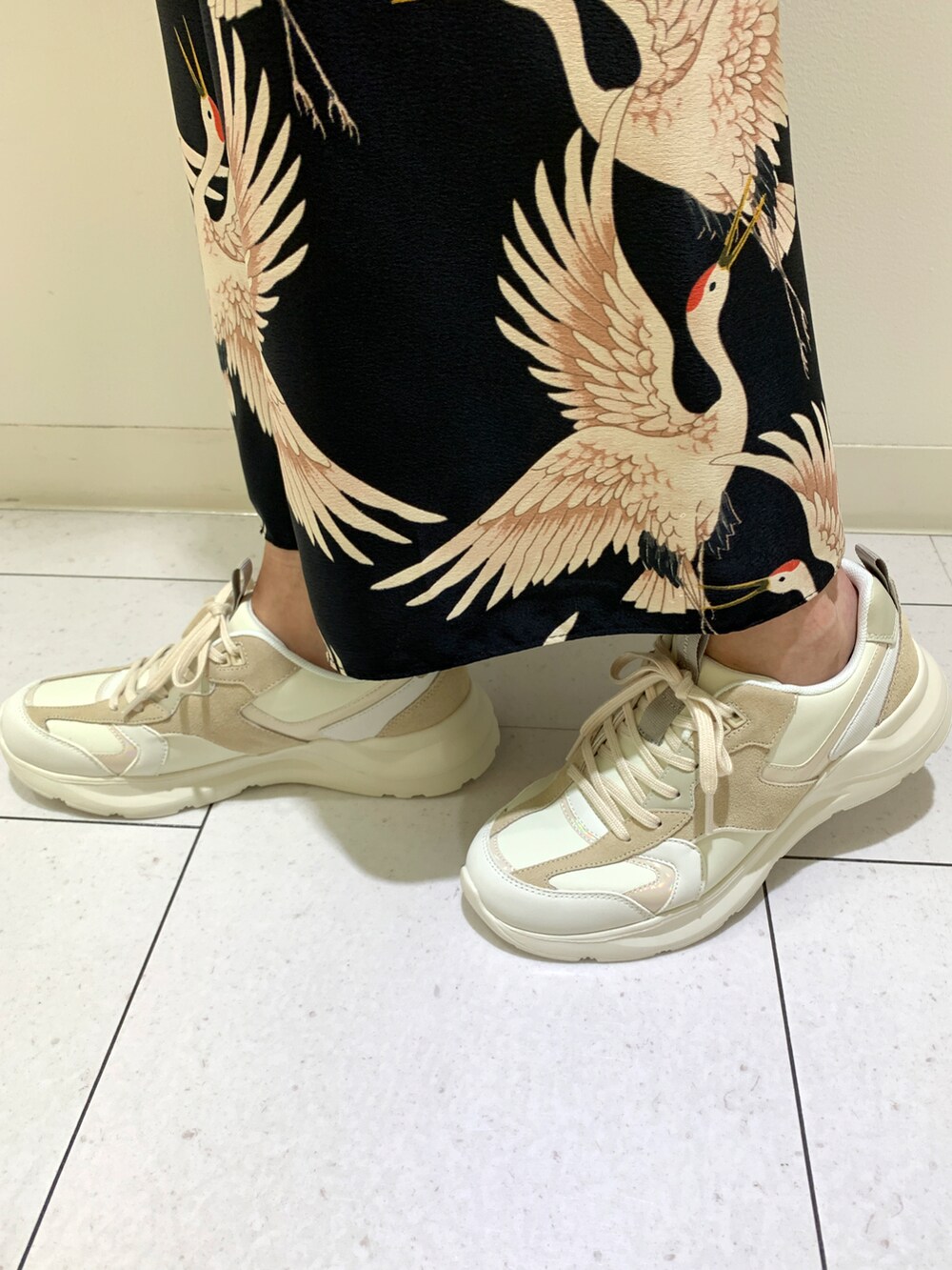 ホワイト系のスニーカーを着用したレディースの春コーディネートの2枚目の写真