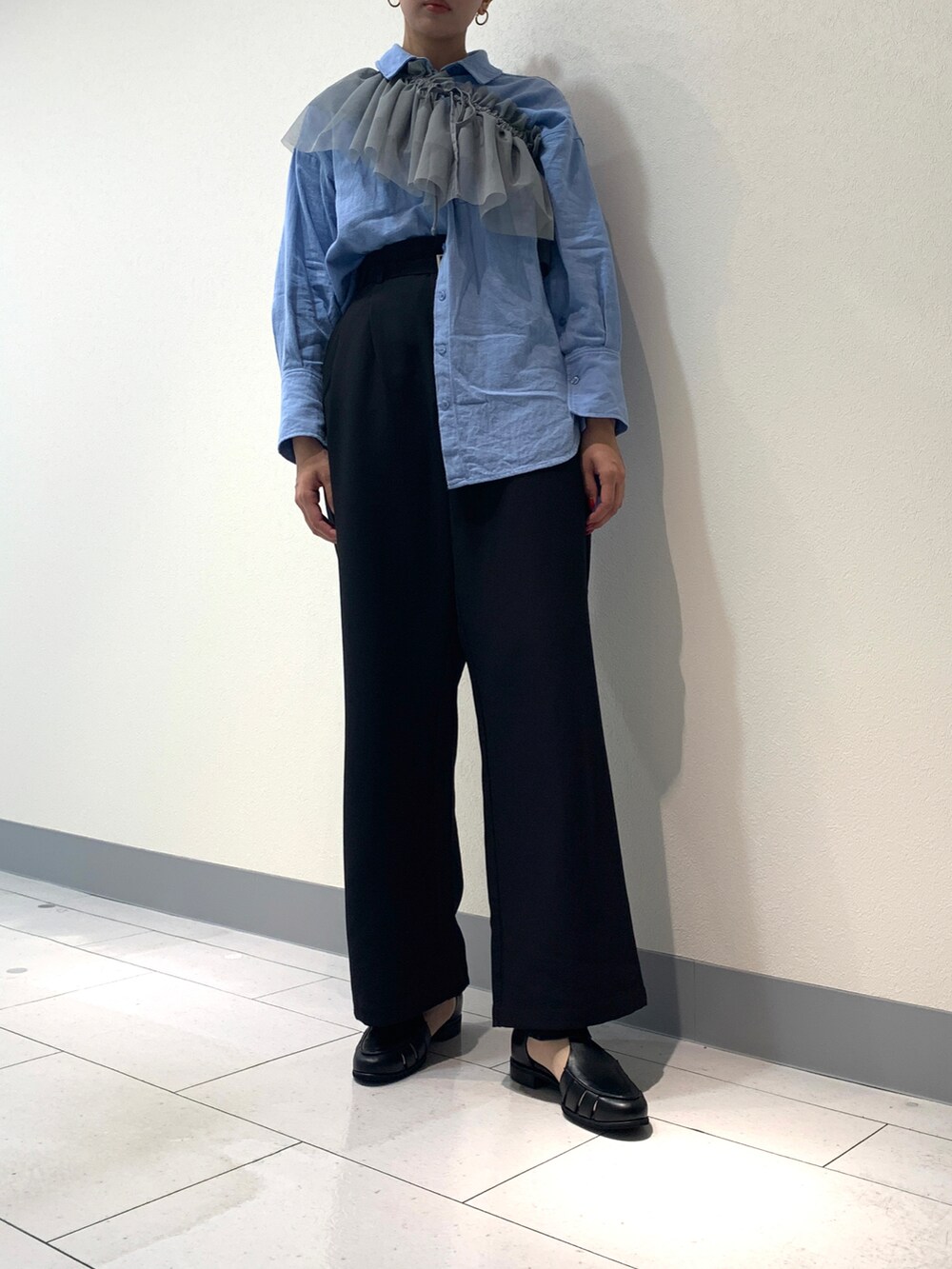 ブラック系のスラックス、ブルー系のシャツ/ブラウス、グレー系のTシャツ/カットソーを着用したレディースの春コーディネートの2枚目の写真