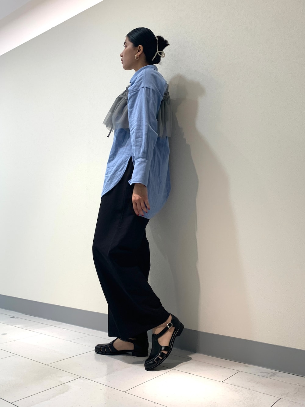 ブラック系のスラックス、ブルー系のシャツ/ブラウス、グレー系のTシャツ/カットソーを着用したレディースの春コーディネートの3枚目の写真