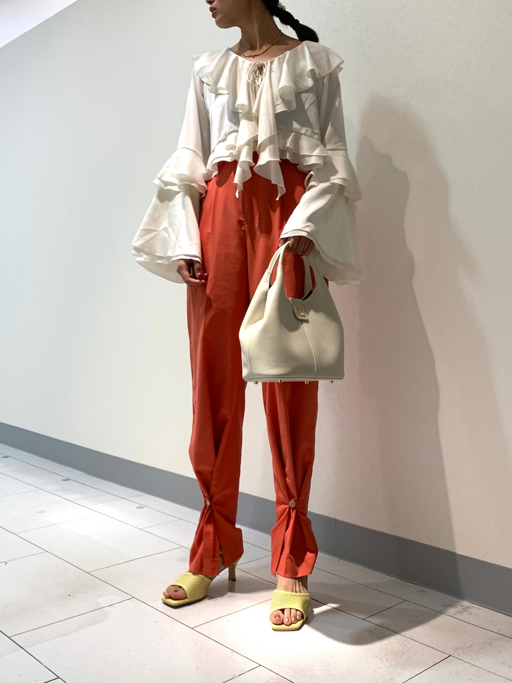 ホワイト系のショルダーバッグ、イエロー系のサンダルを着用したレディースの春コーディネートの2枚目の写真