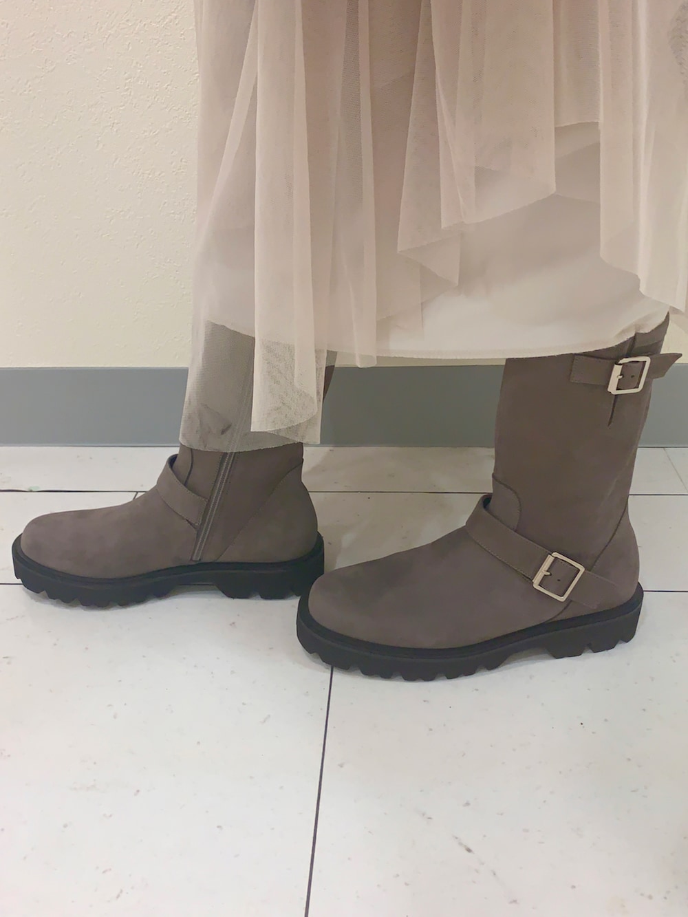 グレー系のブーツを着用したレディースの秋コーディネートの2枚目の写真