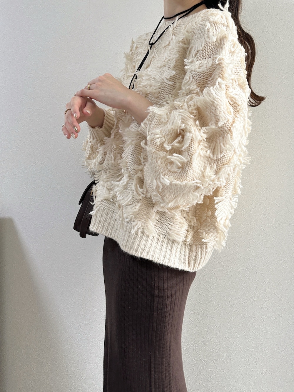 ホワイト系のニット/セーター、ブラウン系のスカートを着用したレディースの冬コーディネートの2枚目の写真