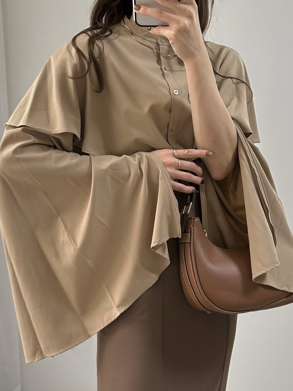 ベージュ系のシャツ/ブラウス、ブラウン系のハンドバッグ、ブラウン系のスカートを着用したレディースの秋コーディネートの2枚目の写真