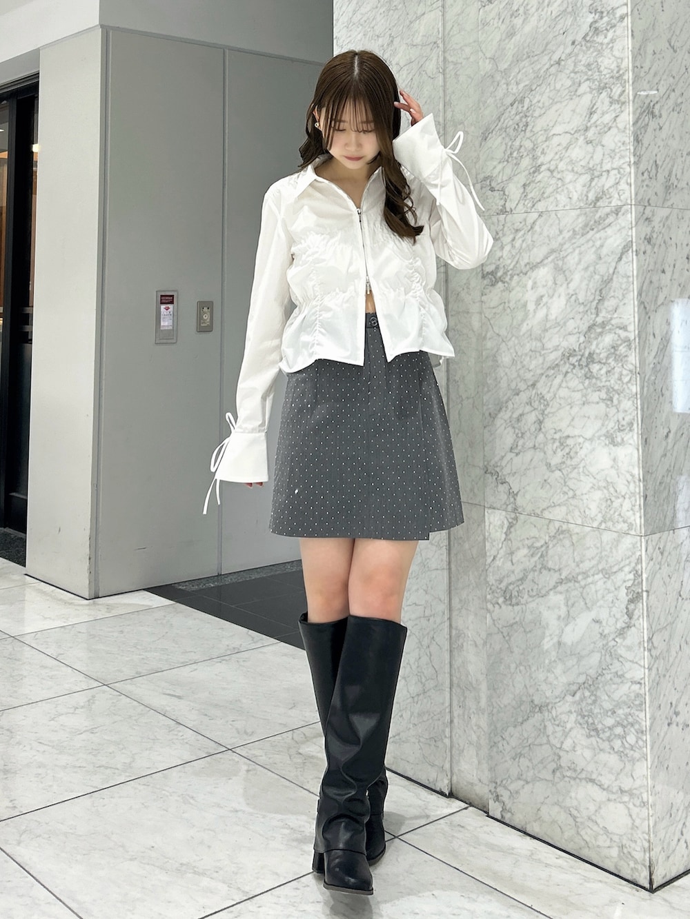 ホワイト系のシャツ/ブラウス、その他のスカート、ブラック系のブーツを着用したレディースの春コーディネートの4枚目の写真