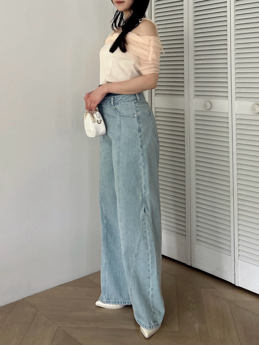 オレンジ系のTシャツ/カットソー、ホワイト系のパンプス、ブルー系のデニムパンツを着用したレディースの夏コーディネートの4枚目の写真