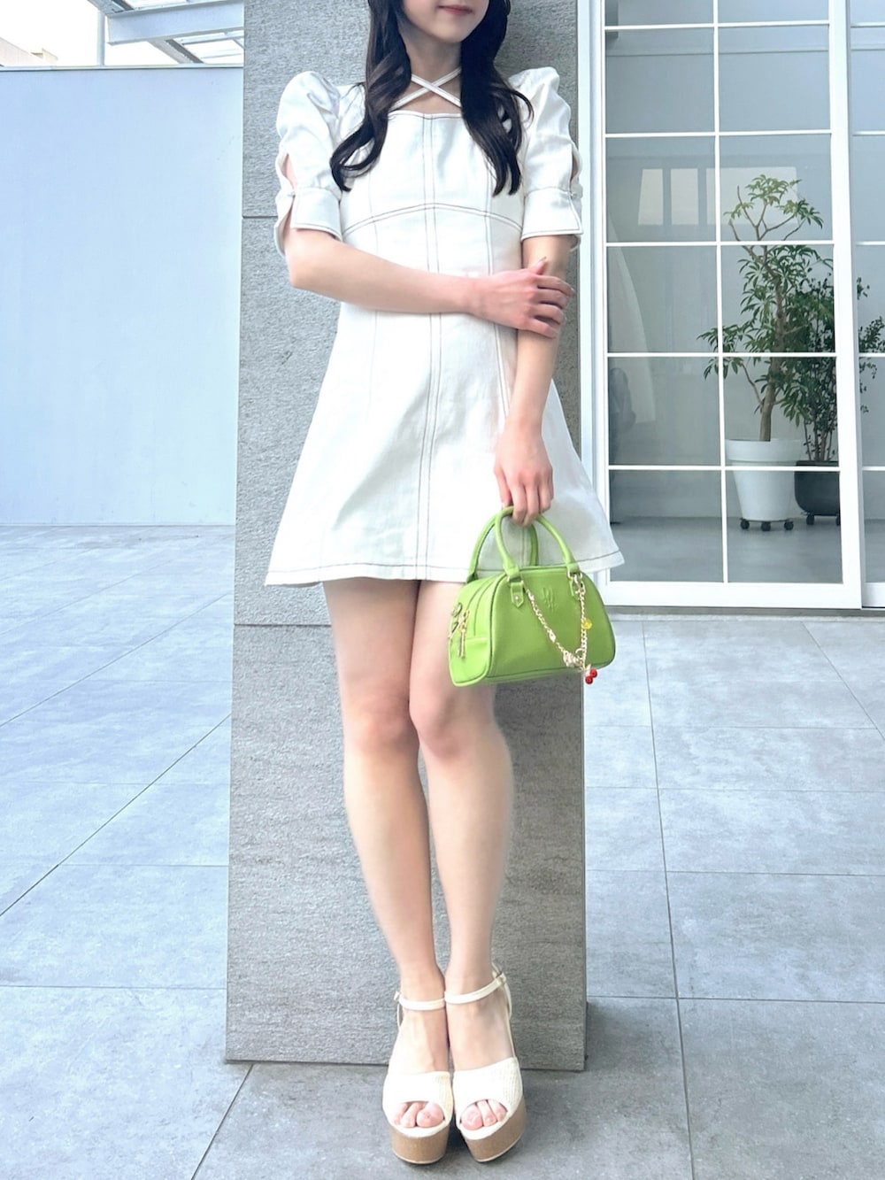 ホワイト系のワンピース、ホワイト系のサンダル、イエロー系のハンドバッグを着用したレディースの春コーディネートの8枚目の写真