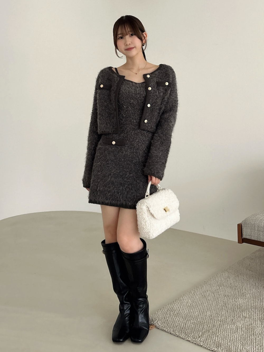 グレー系のノーカラージャケット、グレー系のワンピース、ブラック系のブーツを着用したレディースの冬コーディネートの4枚目の写真