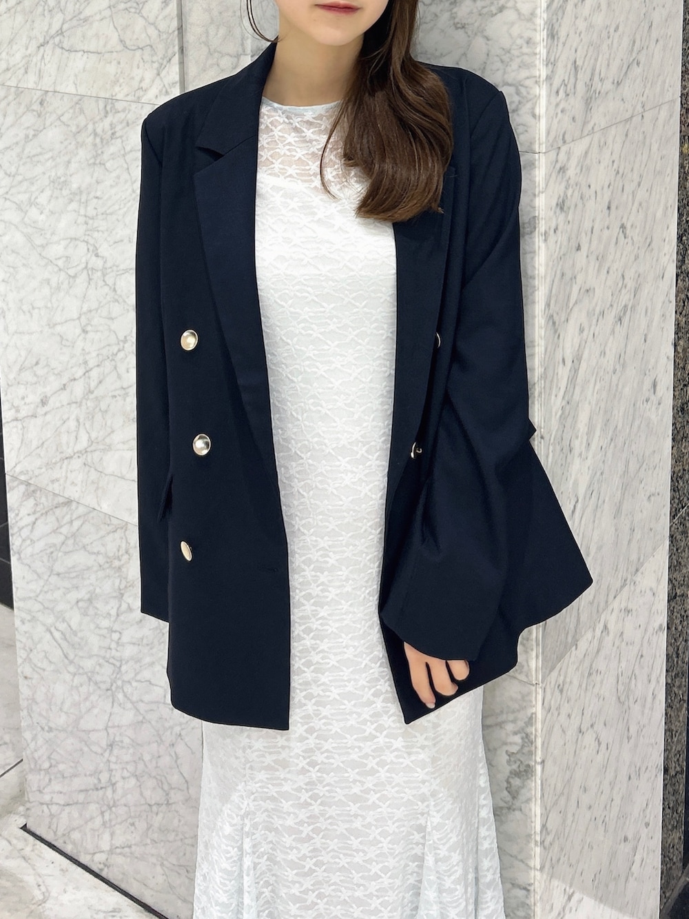 ブルー系のテーラードジャケット、ブルー系のワンピース、ホワイト系のパンプスを着用したレディースの春コーディネートの6枚目の写真