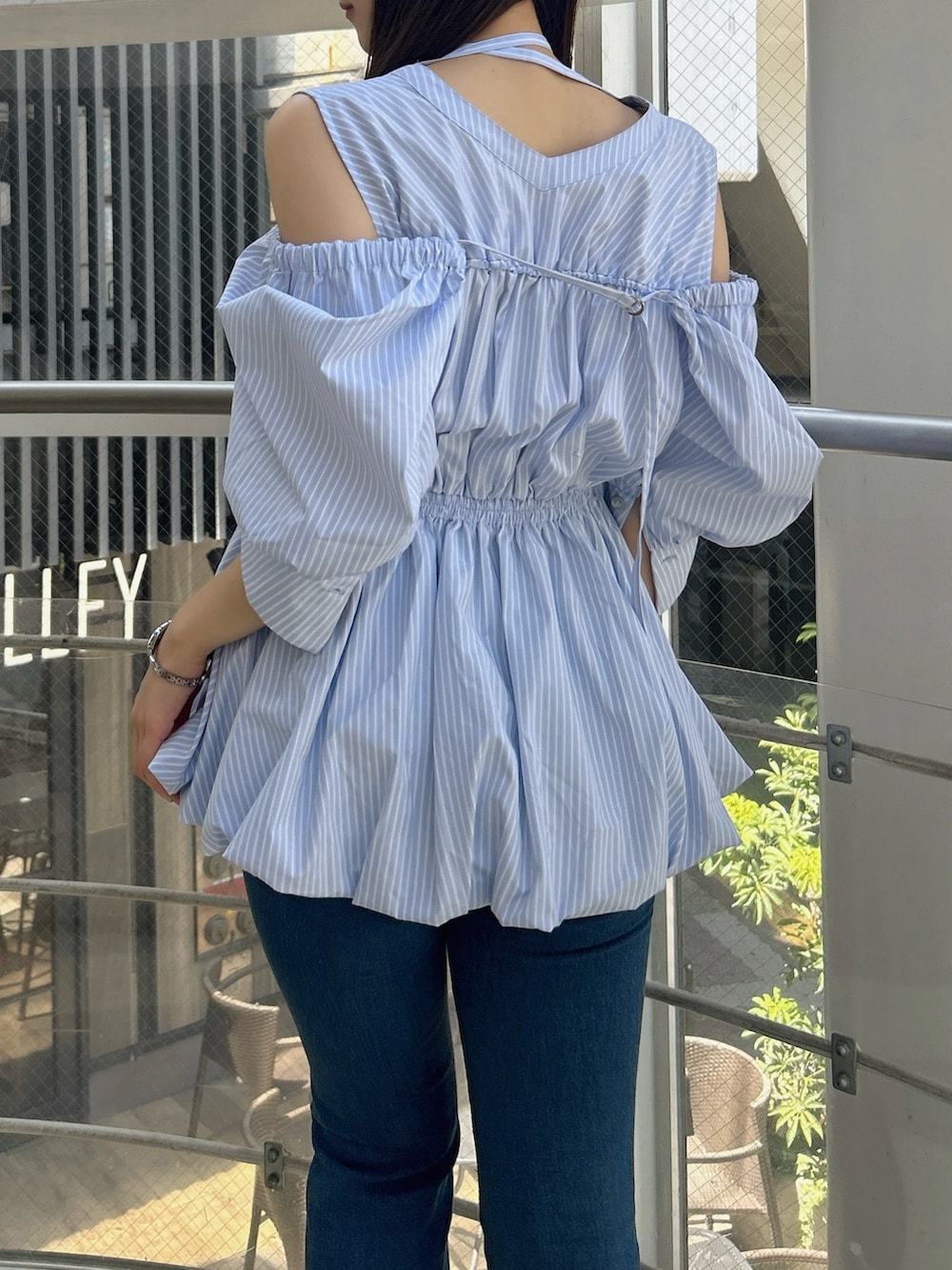 ブルー系のシャツ/ブラウス、ブルー系のデニムパンツ、ホワイト系のサンダルを着用したレディースの秋コーディネートの9枚目の写真