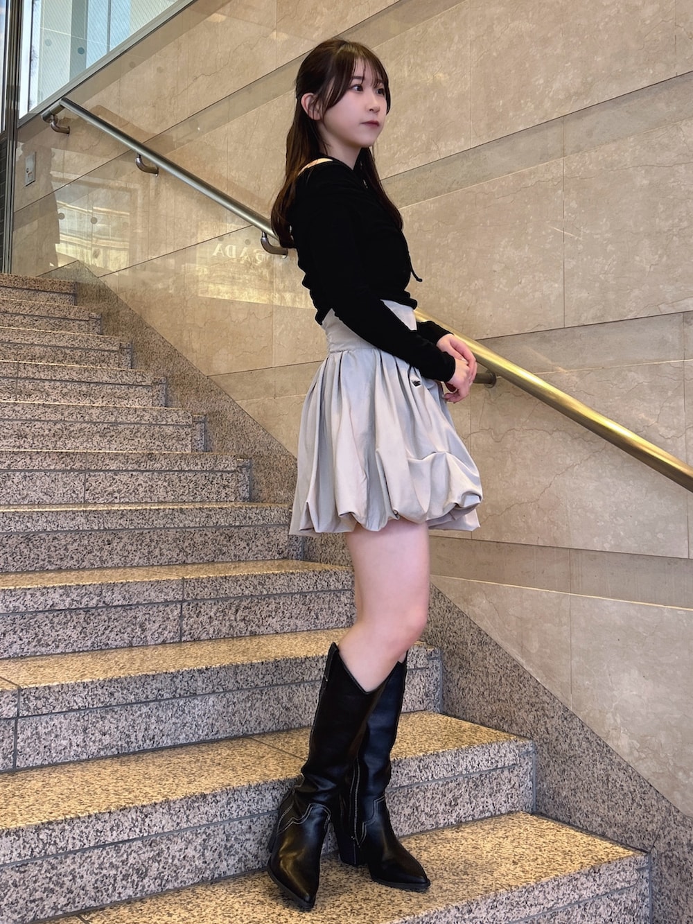 ブラック系のTシャツ/カットソー、ベージュ系のスカート、その他のブーツを着用したレディースの冬コーディネートの2枚目の写真