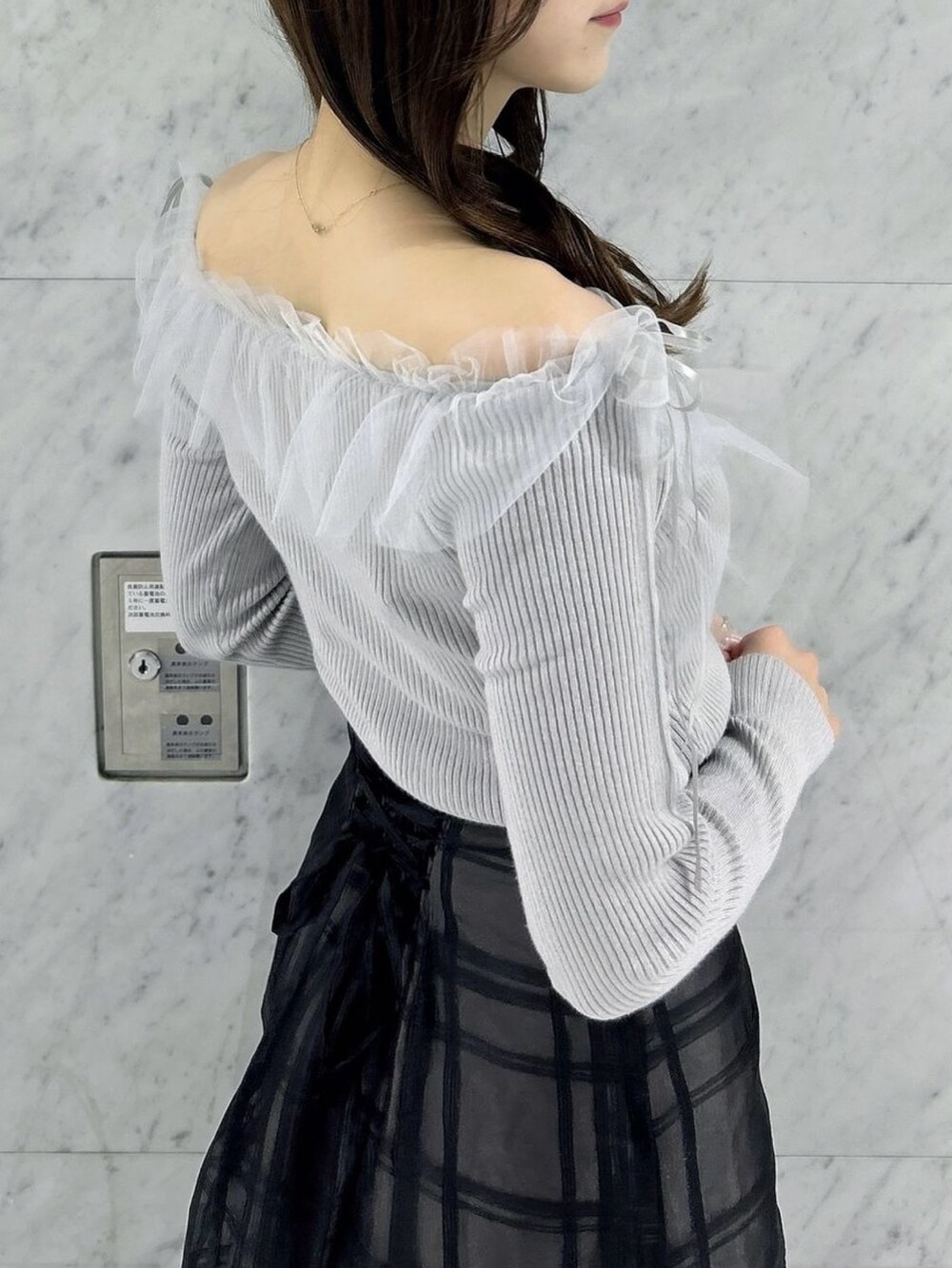 ブラック系のスカート、ブラック系のパンプス、グレー系のニット/セーターを着用したレディースの秋コーディネートの8枚目の写真