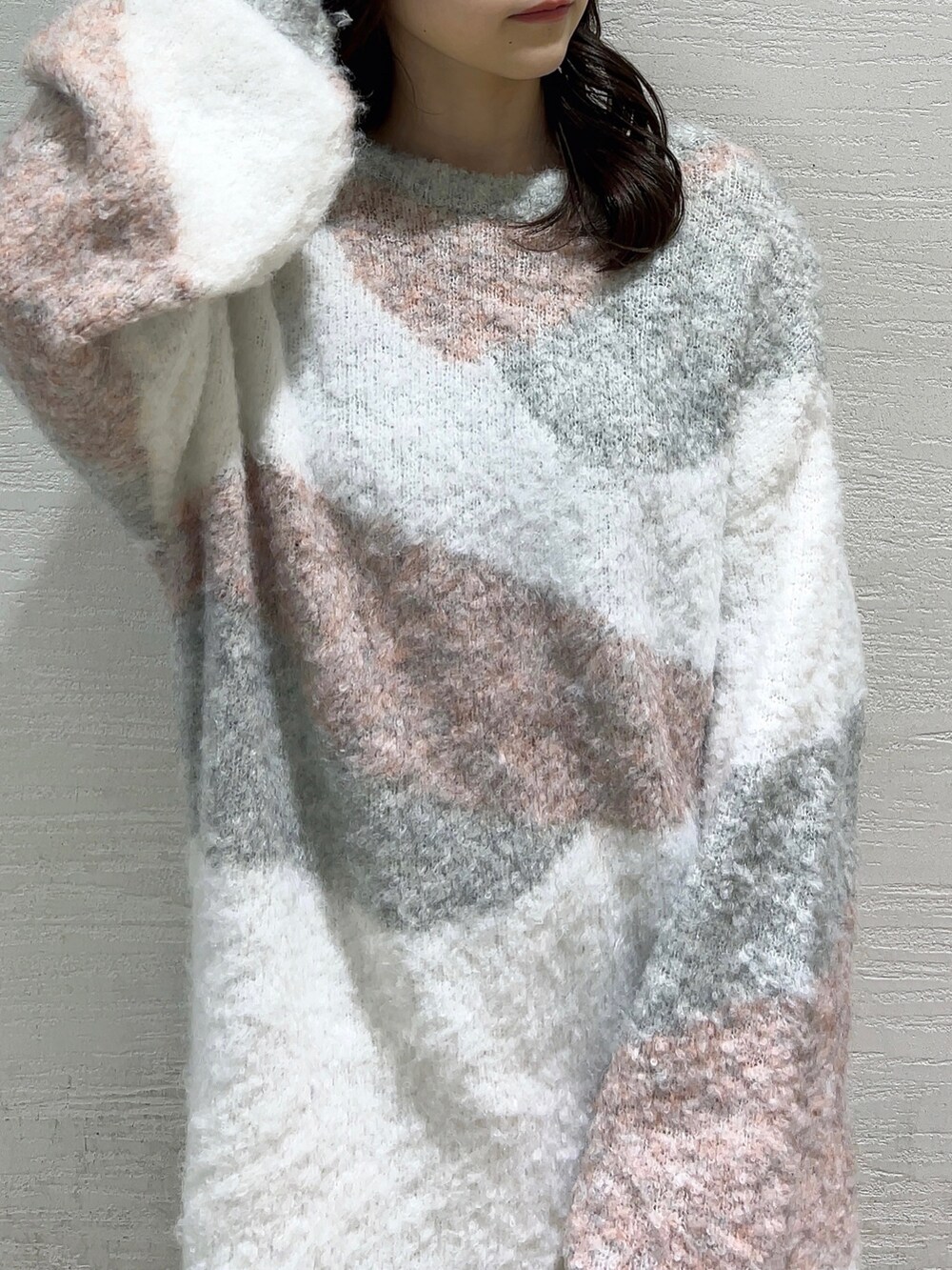 ピンク系のニット/セーター、ホワイト系のスカート、ベージュ系のブーツを着用したレディースの冬コーディネートの7枚目の写真