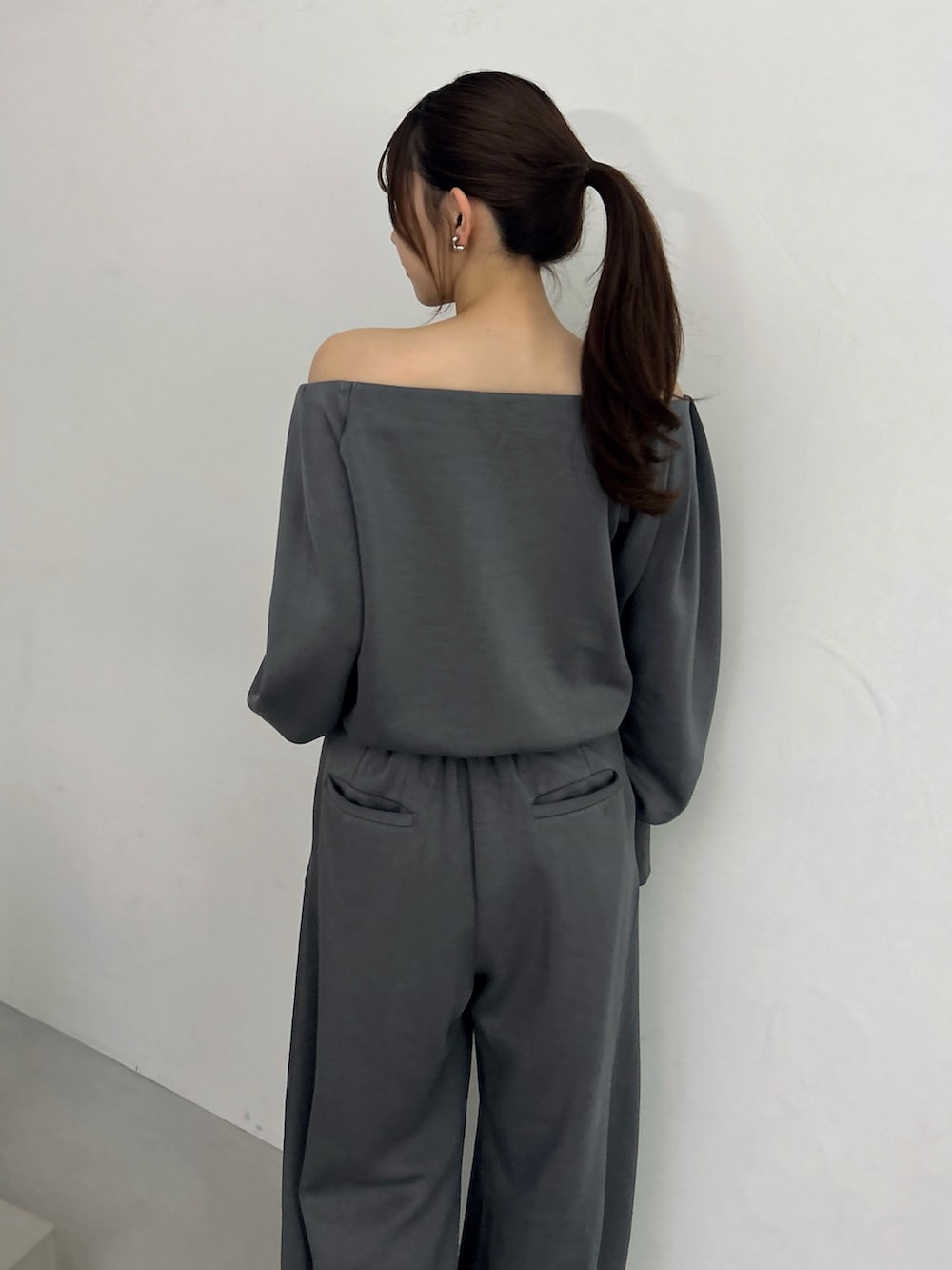 グレー系のスウェット、グレー系のスウェットパンツ、ホワイト系のパンプスを着用したレディースの秋コーディネートの9枚目の写真