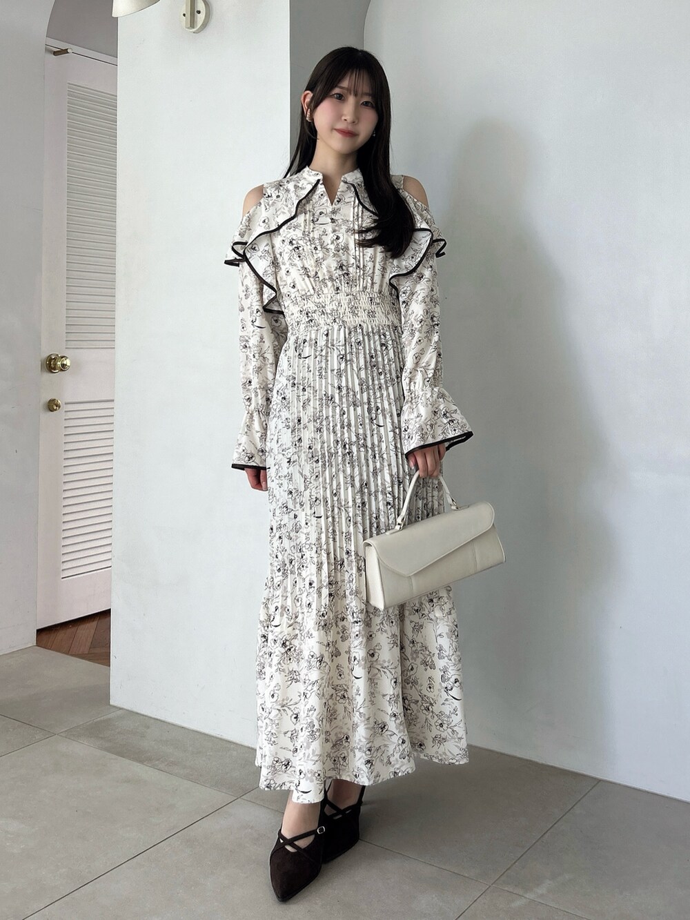 ホワイト系のワンピース、ブラウン系のパンプスを着用したレディースの秋コーディネートの2枚目の写真