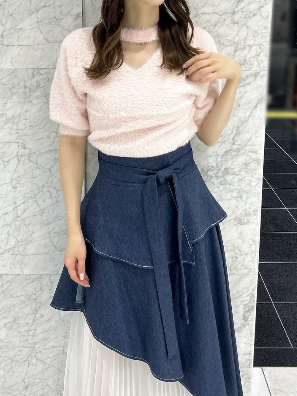 ブルー系のスカート、ブラック系のパンプス、ピンク系のニット/セーターを着用したレディースの秋コーディネートの7枚目の写真