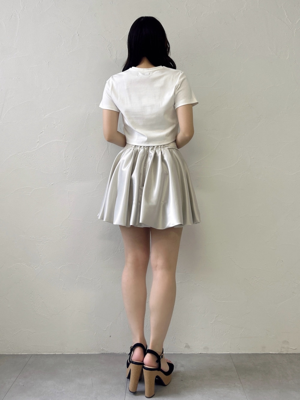 ホワイト系のTシャツ/カットソー、ホワイト系のスカート、ブラック系のサンダルを着用したレディースの春コーディネートの6枚目の写真