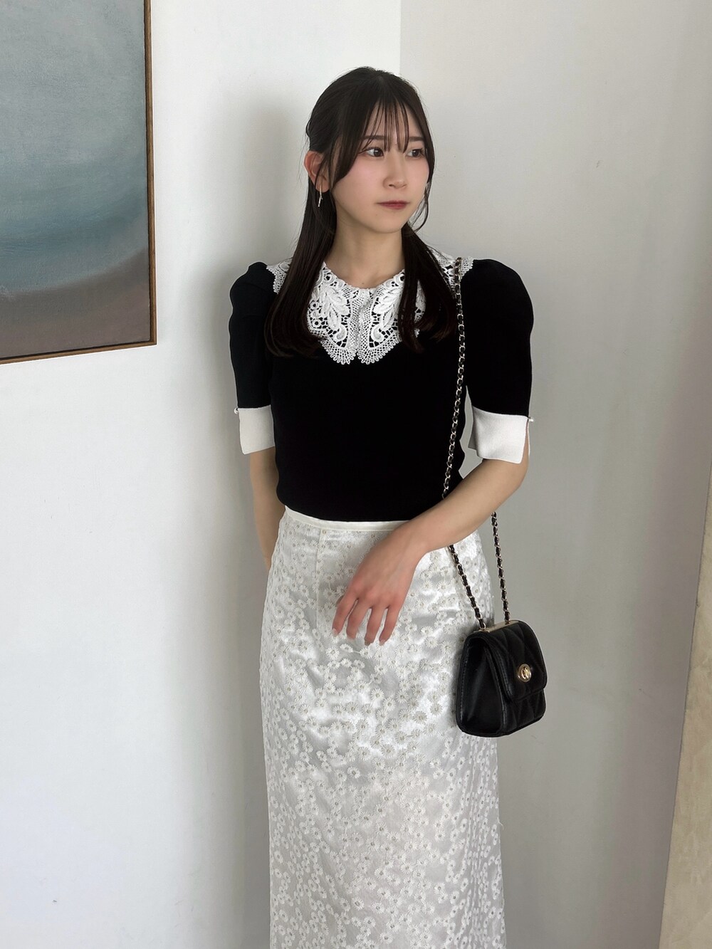 ホワイト系のスカート、ブラック系のニット/セーター、ブラック系のローファーを着用したレディースの春コーディネートの8枚目の写真