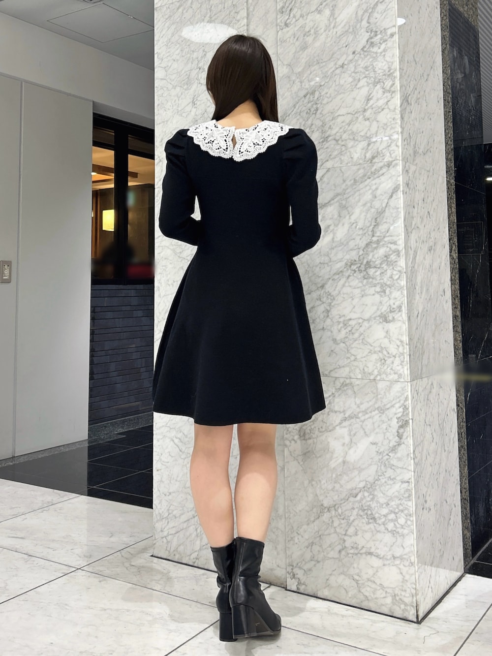 ブラック系のワンピース、ブラック系のブーツを着用したレディースの冬コーディネートの3枚目の写真