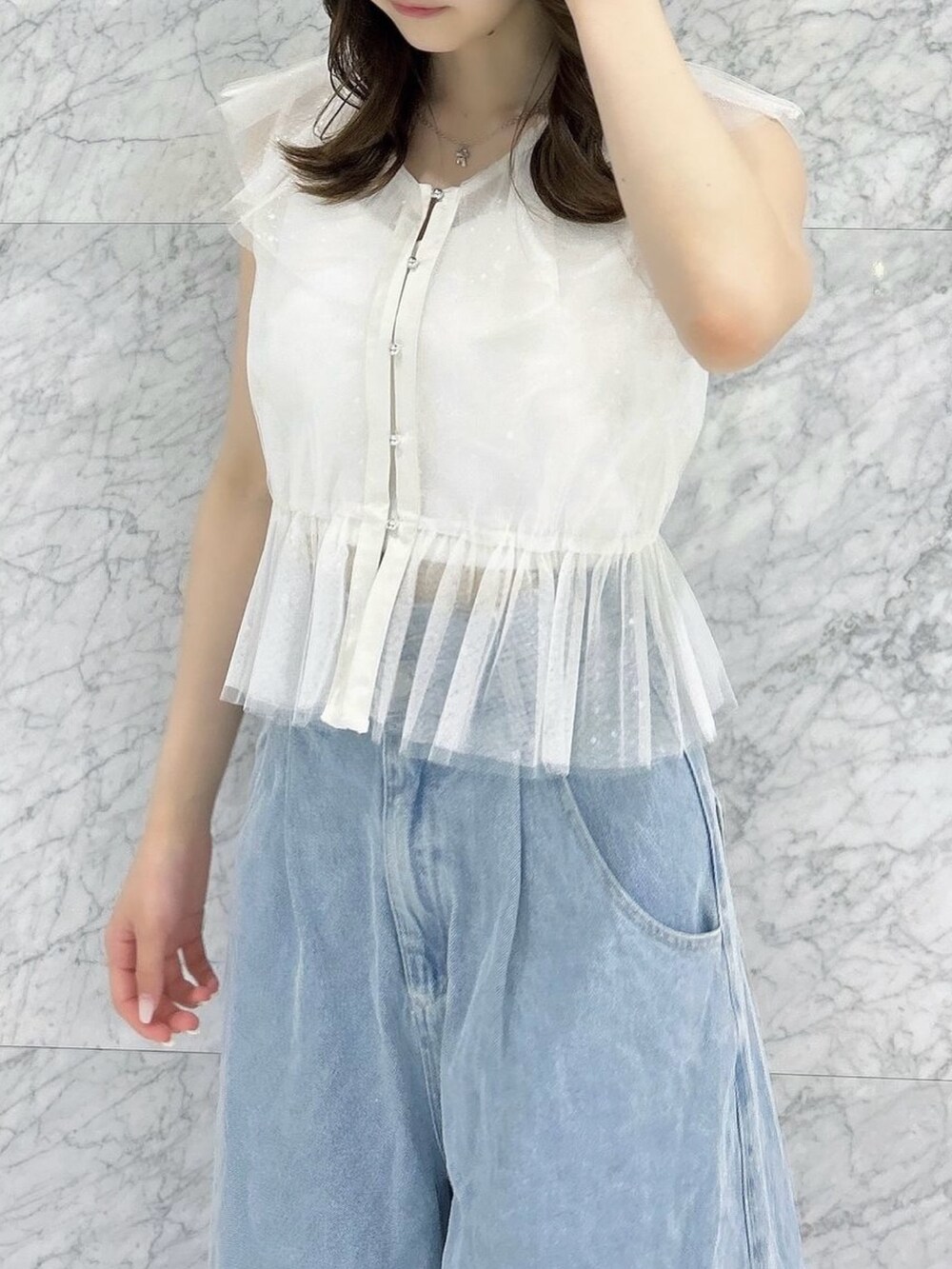 ホワイト系のタンクトップ、ホワイト系のキャミソール、ブルー系のデニムパンツを着用したレディースの夏コーディネートの9枚目の写真