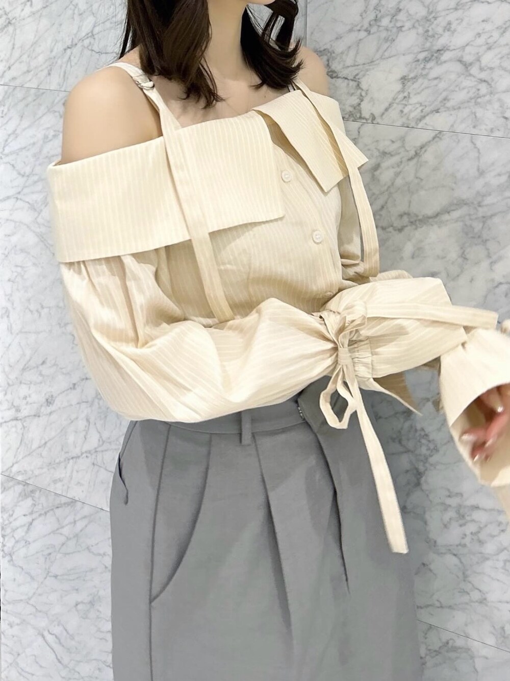 グレー系のスカート、シルバー系のパンプス、イエロー系のシャツ/ブラウスを着用したレディースの春コーディネートの9枚目の写真