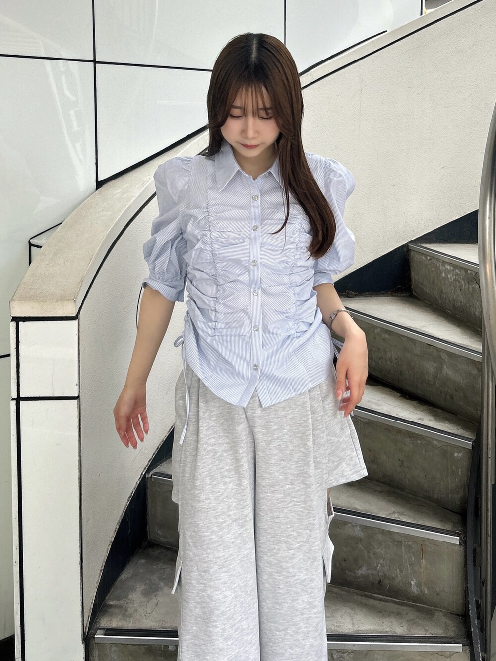 ブルー系のシャツ/ブラウス、グレー系のカーゴパンツ、ホワイト系のパンプスを着用したレディースの夏コーディネートの8枚目の写真