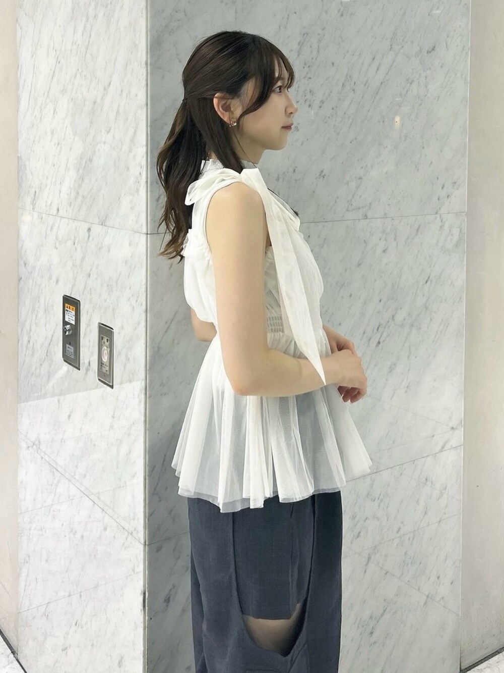 グレー系のニット/セーター、ホワイト系のタンクトップ、ホワイト系のサンダルを着用したレディースの夏コーディネートの9枚目の写真