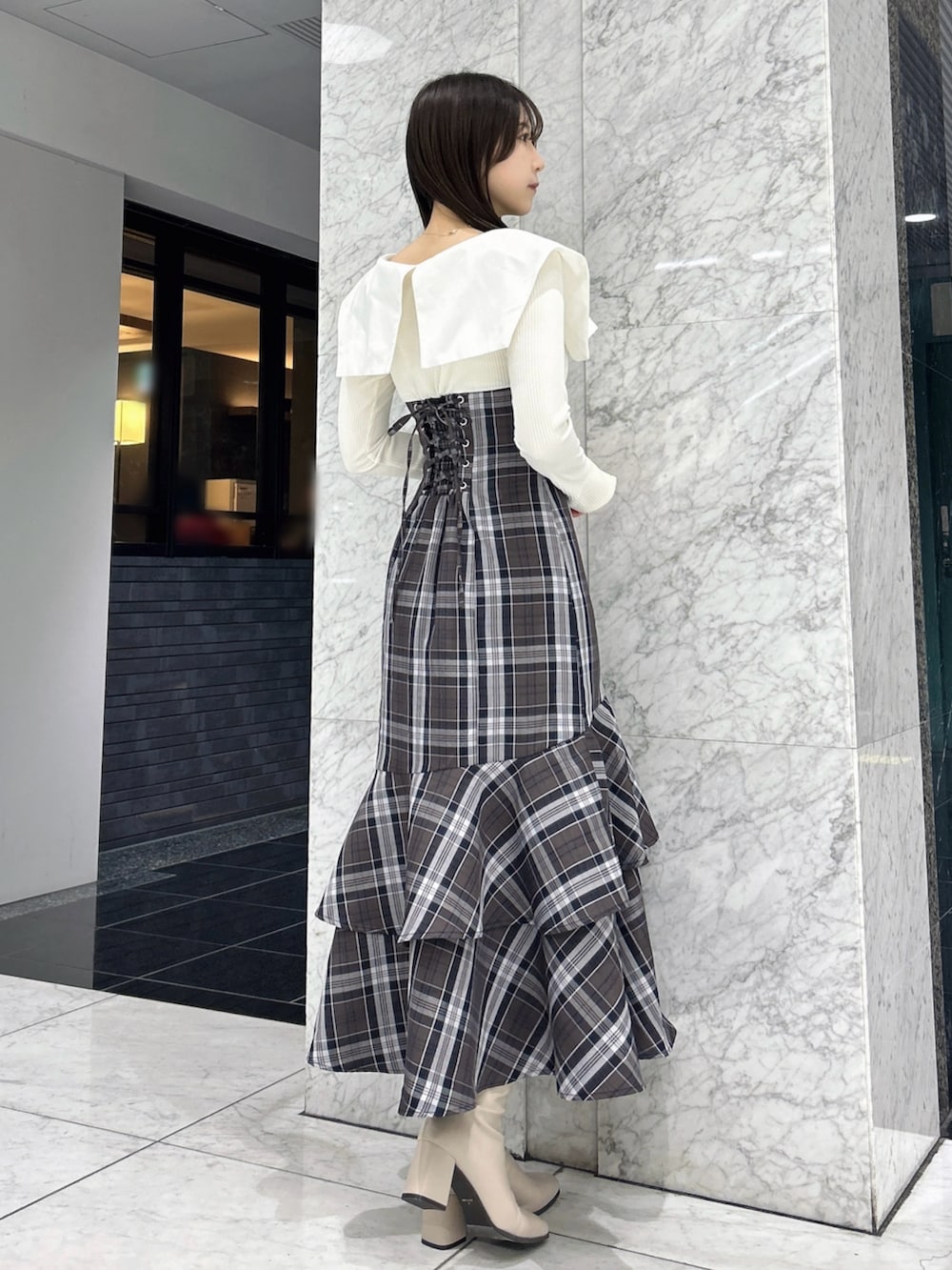 ホワイト系のワンピース、ベージュ系のブーツを着用したレディースの冬コーディネートの3枚目の写真