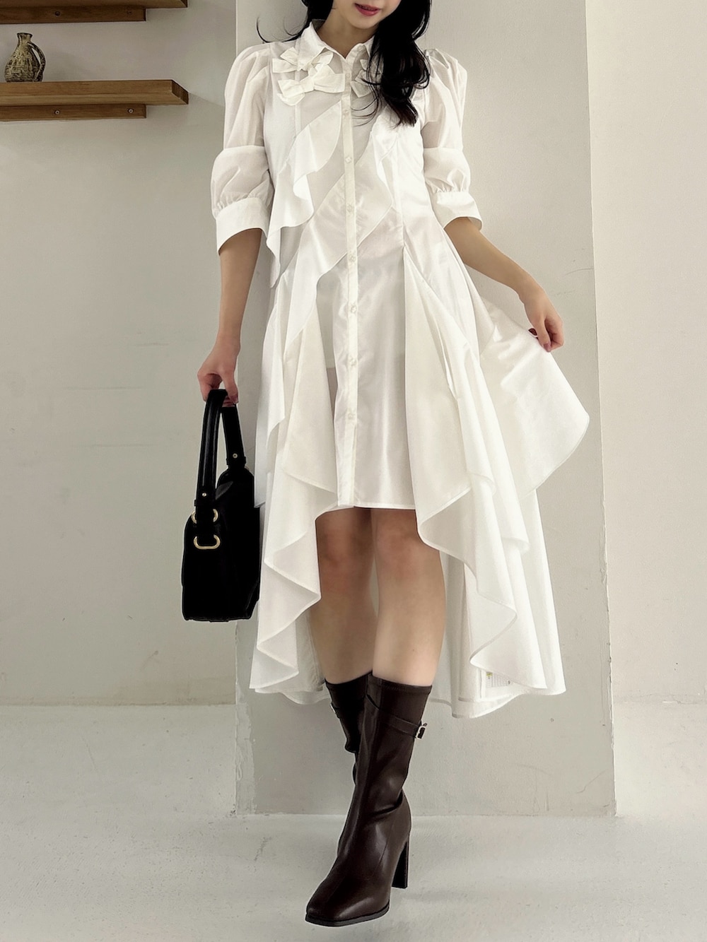 ホワイト系のワンピース、ブラウン系のブーツを着用したレディースの冬コーディネートの4枚目の写真