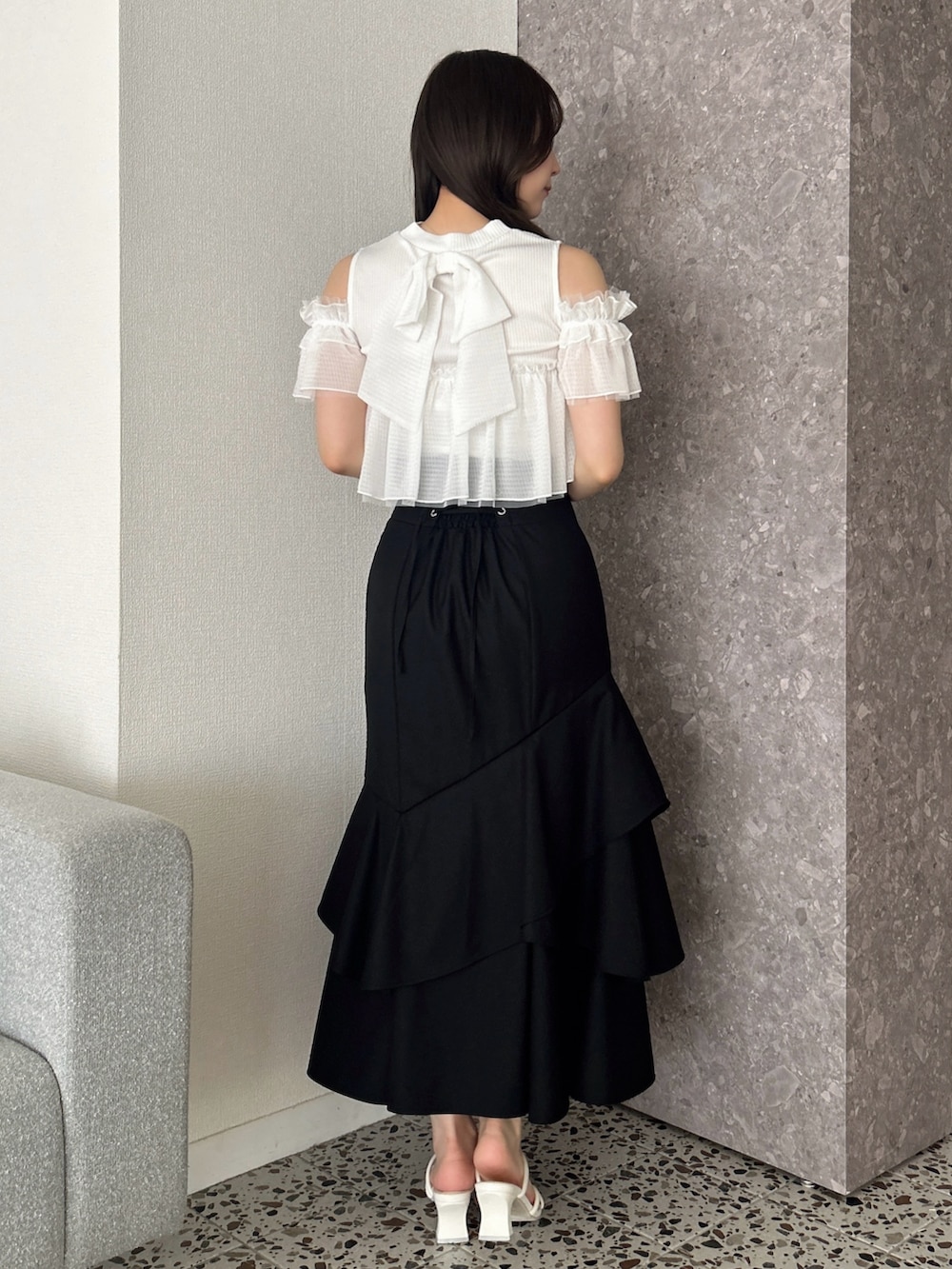 ホワイト系のTシャツ/カットソー、ブラック系のスカート、ホワイト系のサンダルを着用したレディースの春コーディネートの5枚目の写真