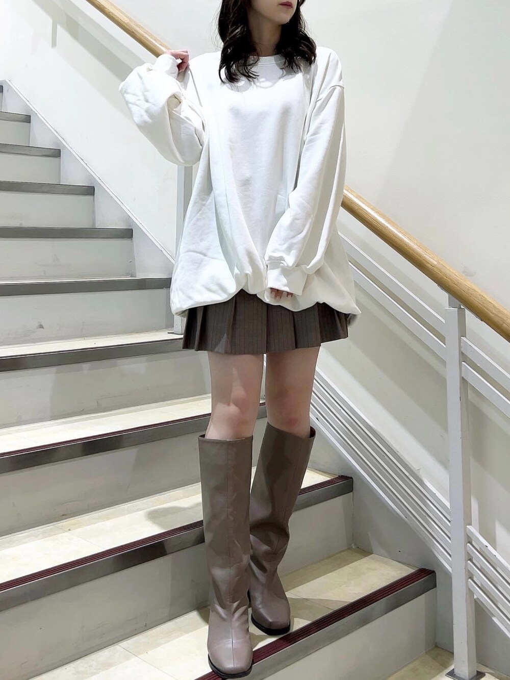 ホワイト系のTシャツ/カットソー、ベージュ系のスカート、ベージュ系のブーツを着用したレディースの冬コーディネートの4枚目の写真