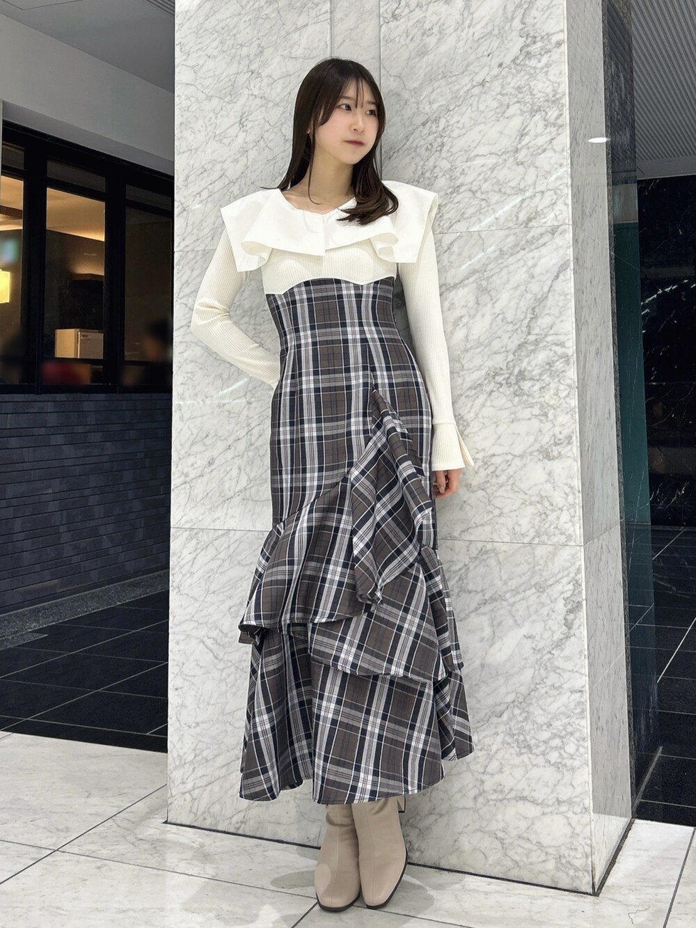 ホワイト系のワンピース、ベージュ系のブーツを着用したレディースの冬コーディネートの4枚目の写真