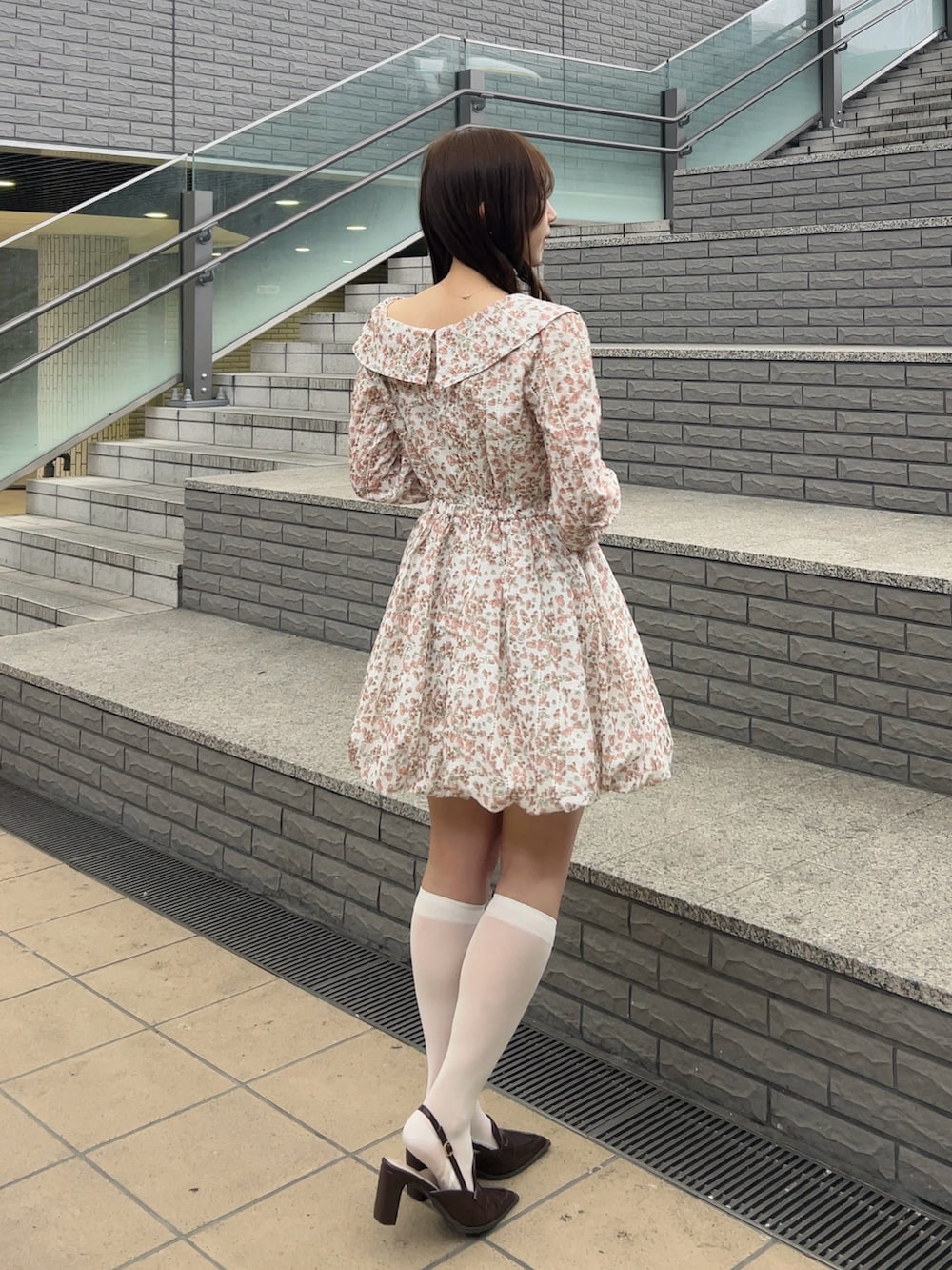 オレンジ系のワンピース、ブラウン系のローファーを着用したレディースの春コーディネートの4枚目の写真