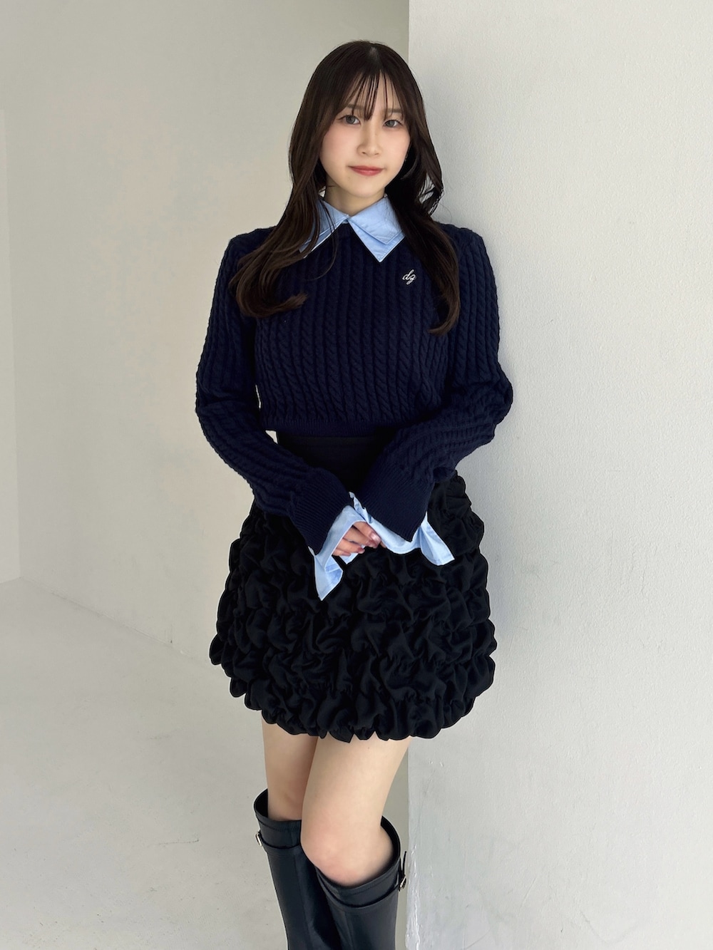 ブラック系のブーツ、ブラック系のスカート、ブルー系のニット/セーターを着用したレディースの冬コーディネートの6枚目の写真