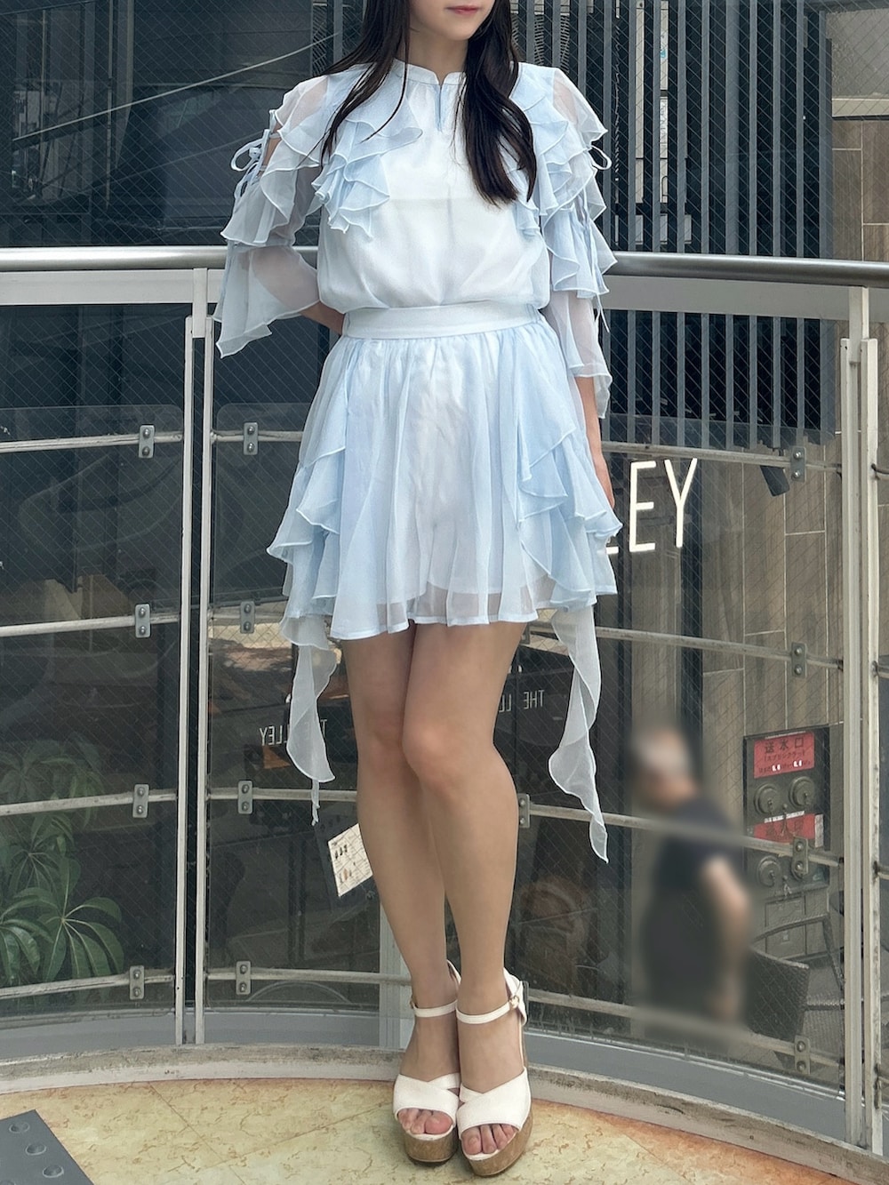 ブルー系のシャツ/ブラウス、ブルー系のスカート、ホワイト系のサンダルを着用したレディースの秋コーディネートの3枚目の写真