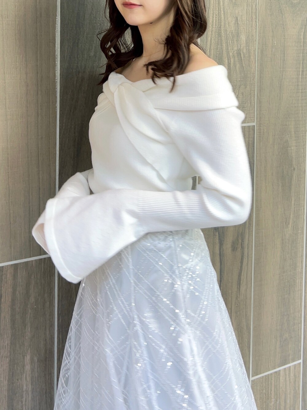 ホワイト系のニット/セーター、グレー系のスカート、ホワイト系のブーツを着用したレディースの冬コーディネートの7枚目の写真