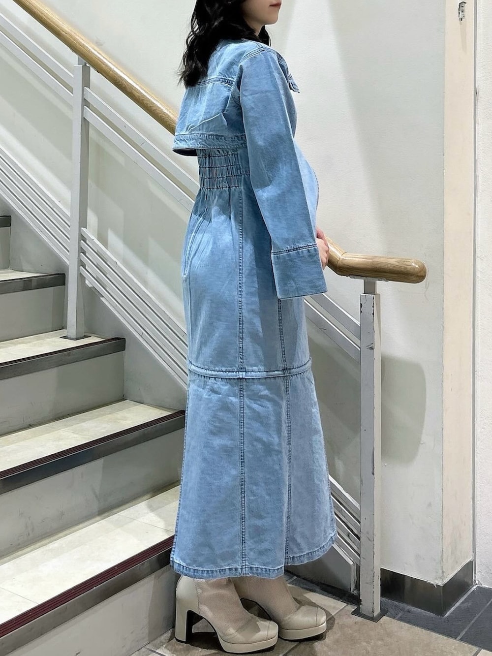 ブルー系のワンピース、ホワイト系のブーツを着用したレディースの春コーディネートの5枚目の写真