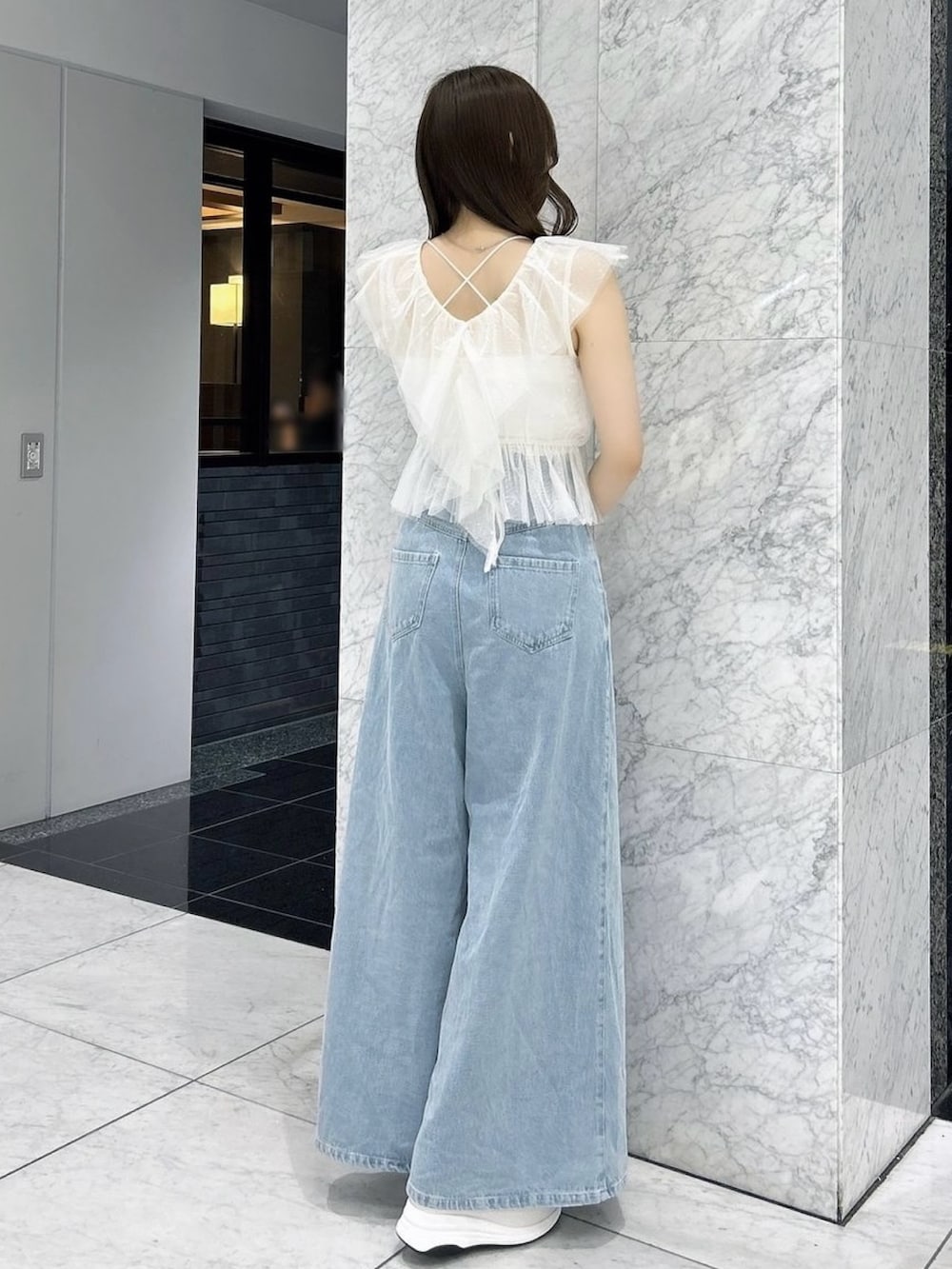 ホワイト系のタンクトップ、ホワイト系のキャミソール、ブルー系のデニムパンツを着用したレディースの夏コーディネートの5枚目の写真